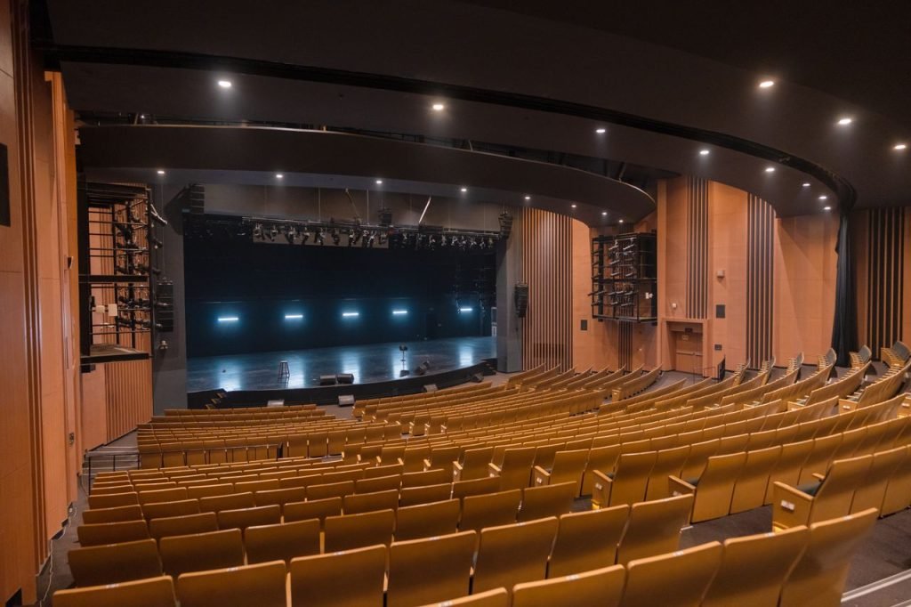 Home Spacious empty theatre auditorium with wooden seating in Varanasi, India.